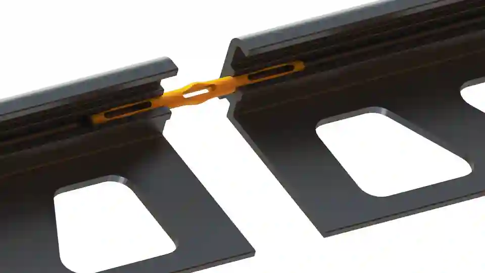 Produktdetailaufnahme von Schlüter-JOLLY-V Steckverbinder halb eingesteckt zwischen zwei JOLLY-Kantenschutzprofilen in MGS Graphitschwarz matt