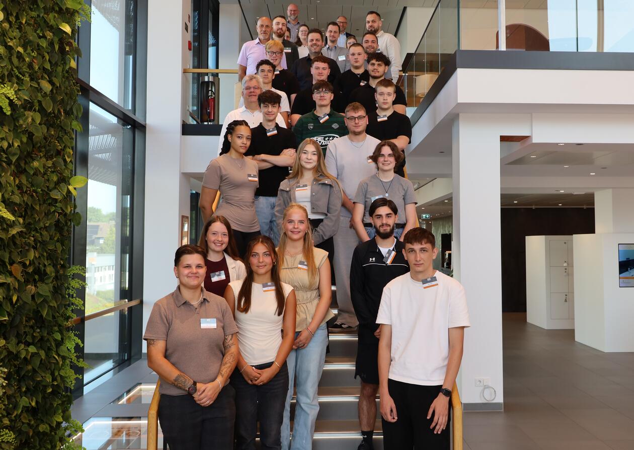 19 neue Auszubildende haben am 3. August ihre Ausbildung bei Schlüter-Systems begonnen. 19 neue Auszubildende haben am 3. August ihre Ausbildung bei Schlüter-Systems begonnen. Sie stehen gemeinsam mit Ausbilderinnen und Ausbildern auf der Treppe der Schlüter-WorkBox.