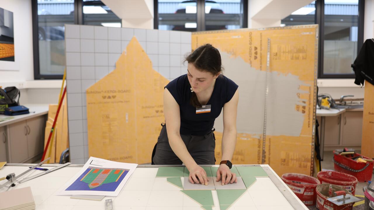 Das Team war hochkonzentriert bei der Sache, um die anspruchsvolle Aufgabe fertigzustellen. Die junge Fliesenlegerin Miriam Zeller bei der Arbeit an ihrem Modell.