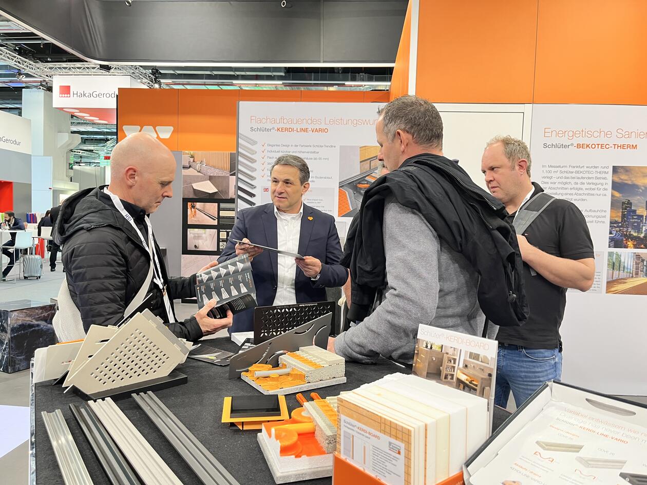 Konzultace s několika návštěvníky veletrhu u výstavního stolu na veletrhu ISH.