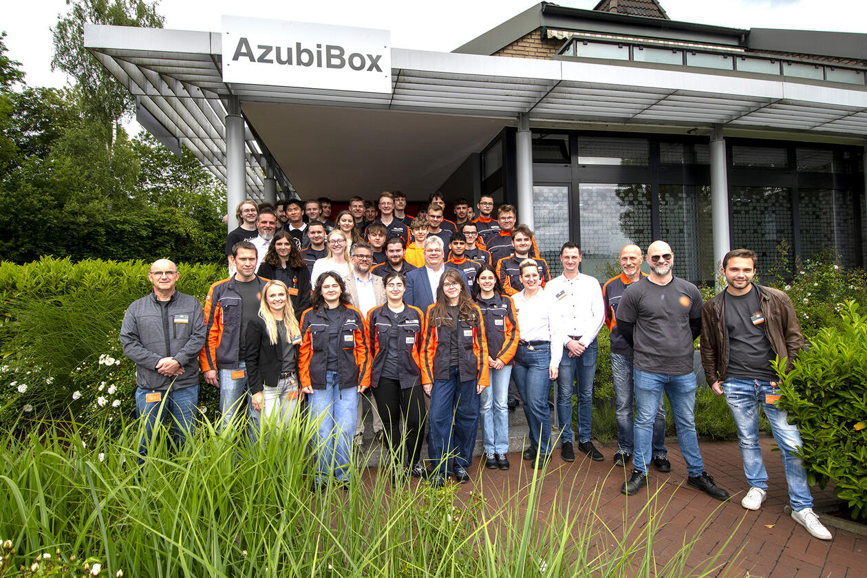 Die Auszubildenden mit den Geschäftsführern Udo und Marc Schlüter sowie ihren Ausbildern vor der neuen AzubiBox.