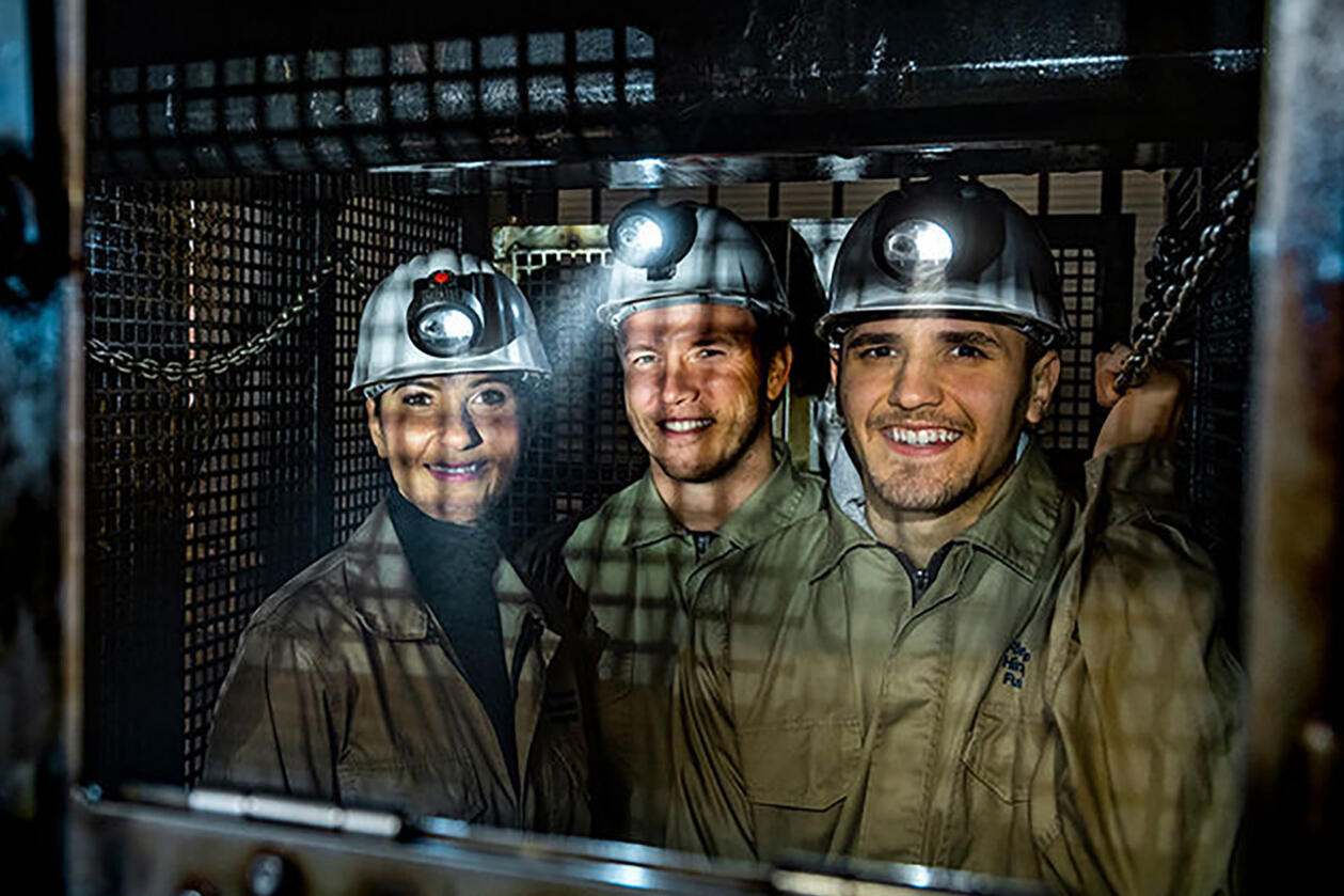 Aufnahme von drei ausgerüsteten Besuchenden des Silberbergwerks.