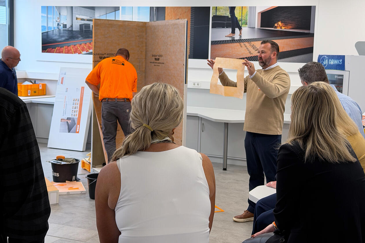 Praxisteil eines Workshops rund um Abdichtung: Blick auf Handwerker, der Schlüter-Produkte verarbeitet