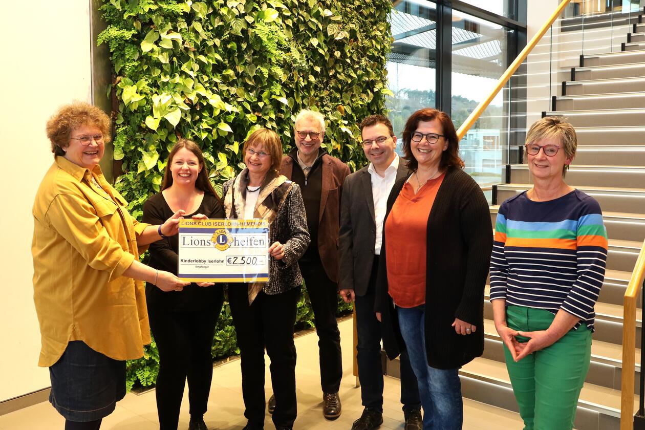 Monika Körner-Weinert (ganz links), Vorsitzende der Kinderlobby, nimmt den symbolischen Spendenscheck vom Lions Club in der Schlüter-WorkBox entgegen.