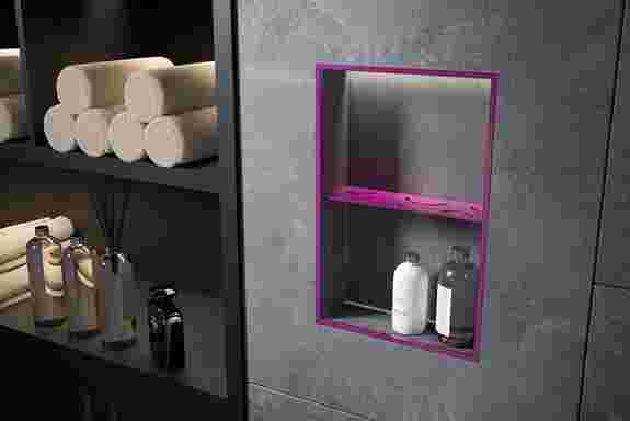 Grau gefliestes Badezimmer, welches unter anderem eine Nische hat, die mit lilafarbenen Profilen und einer Ablage farblich hervorgehoben ist.