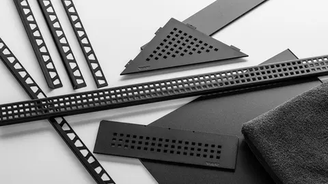 A selection of Schlüter-Systems products in MGS matte graphite black finish (here including JOLLY, QUADEC, RONDEC edge protection profiles, KERDI-LINE shower channel and SHELF shower shelf)