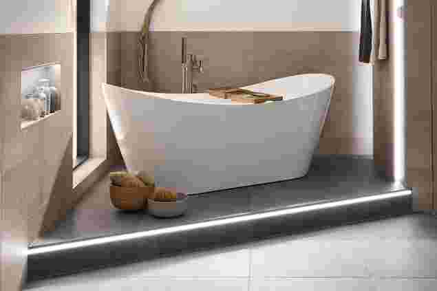 Free-standing bathtub and illuminated base with Schlüter-LIPROTEC.