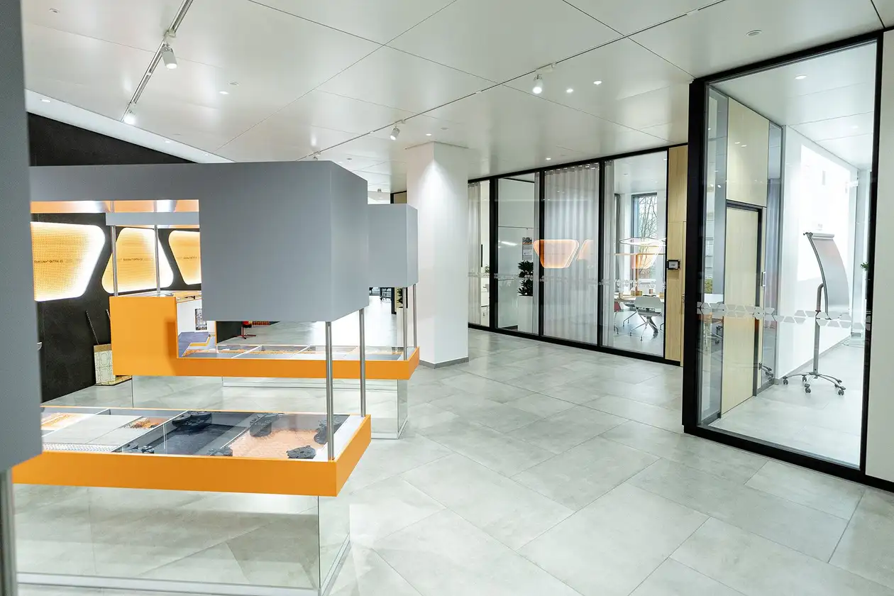 Corridor with a view of meeting rooms behind glass fronts in the Schlüter Systems office building