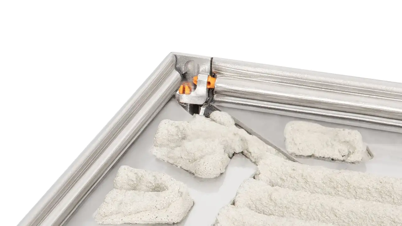 Detailed product illustration of an outside skirting corner before application of tile, focusing on the preparation of the JOLLY edge protection profiles and the innovative corner joint system in brushed stainless steel