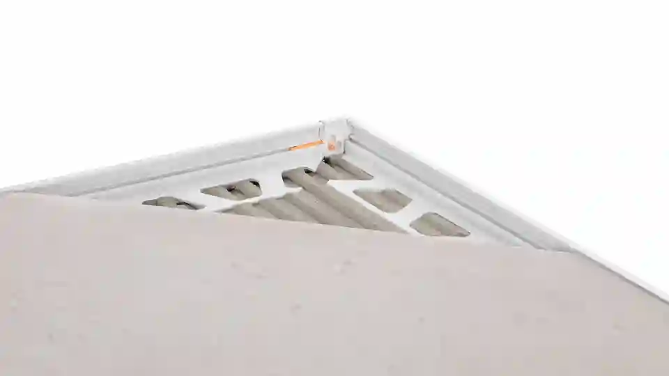 Detailed product illustration of an outside skirting corner with tile in place, focusing on the prepared JOLLY edge protection profiles beneath and the innovative corner joint system