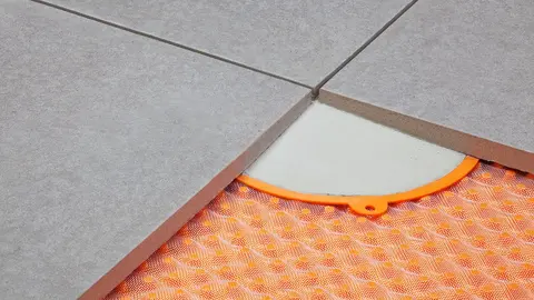 Terrace pavers fixed with thin-bed mortar elements over a surface drain