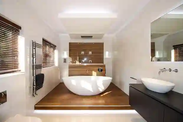 Freestanding bathtub surrounded by wood-effect floor tiles and a shower area in the background.