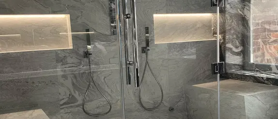 Shower area in the steam bath with two seating areas, two niches and two showers on the two sides.