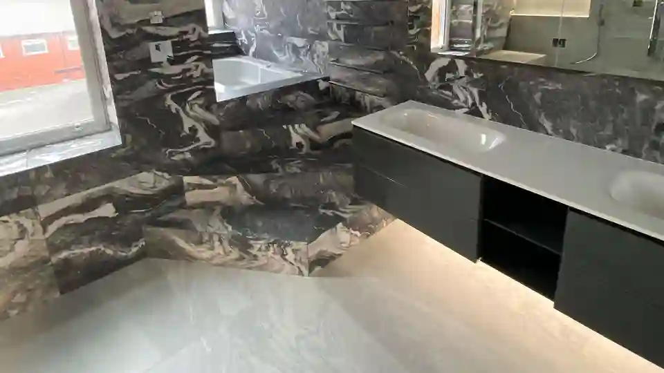 A wall-mounted vanity unit on the right and a whirlpool with access steps in the background.