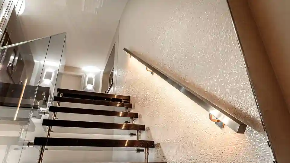 Staircase with lighting positioned behind the handrail