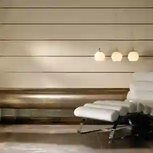 Wellness area with a bench finished in metal-look tiles and a white lounger