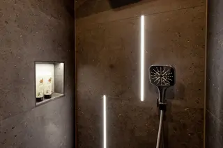 Shower with LIPROTEC cove lighting and KERDI-BOARD-NLT illuminated niche.