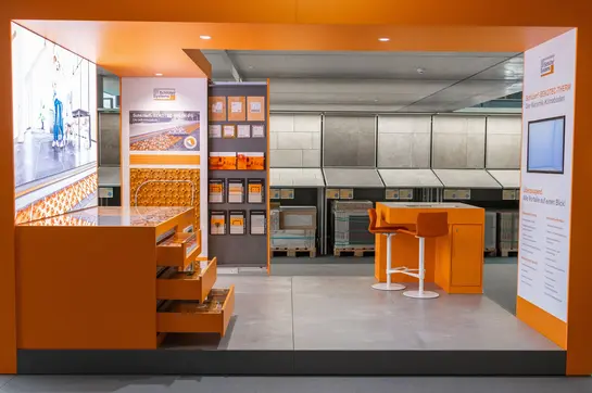 Aufnahme des Ausstellungsmoduls BEKOTEC CompetenceCenter mit Pr&auml;sentationsfl&auml;chen, Musterst&uuml;cken und einer Videowand.