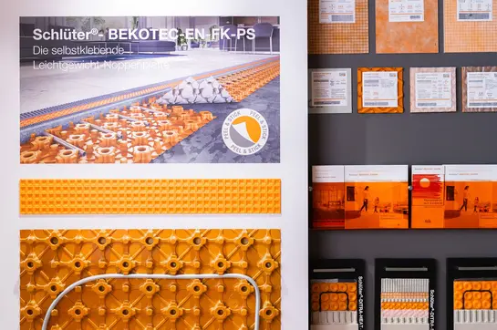 Angebrachte Estrichnoppenplatte mit Heizrohr, erg&auml;nzt durch Musterst&uuml;cke, Handmodelle und Brosch&uuml;ren.