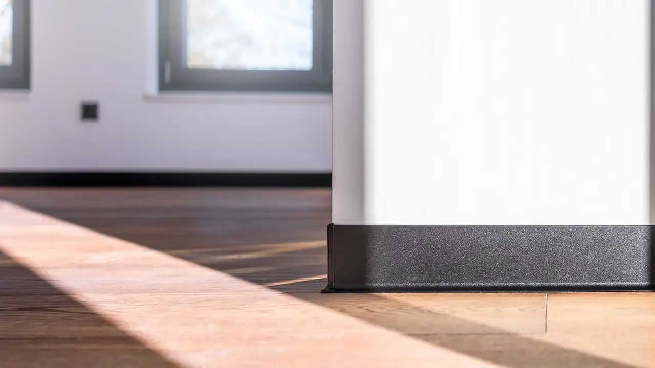 Schwarze Sockelleiste an heller Wand