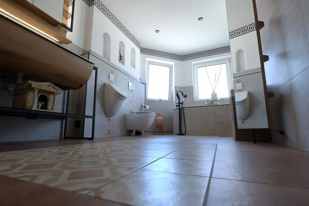 Blick in das Bad, das Stilelemente der römischen Antike mit modernem Komfort verbindet.