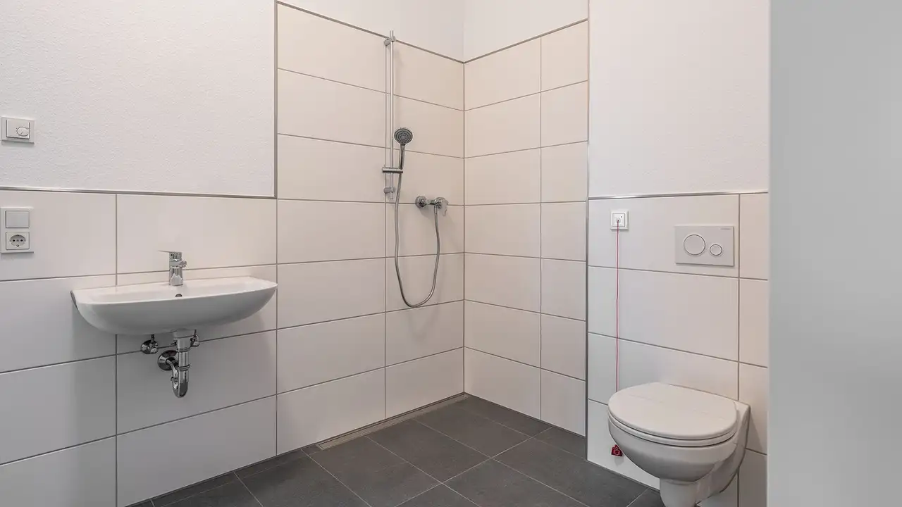 Helles, barrierefreies Bad mit WC, Duschbereich und Waschbecken