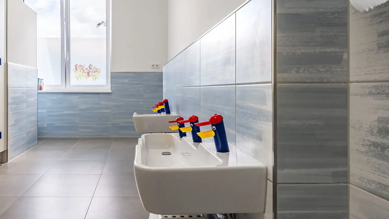 Kindgerechte Waschtische mit bunten Wasserhähnen in Entenform im Kindergarten der Marktschule