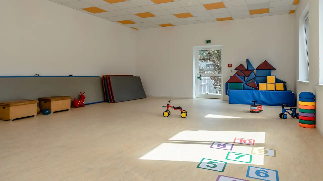 Großer Turnraum im Kindergarten der Marktschule mit Matten, Turnelementen und Spielen