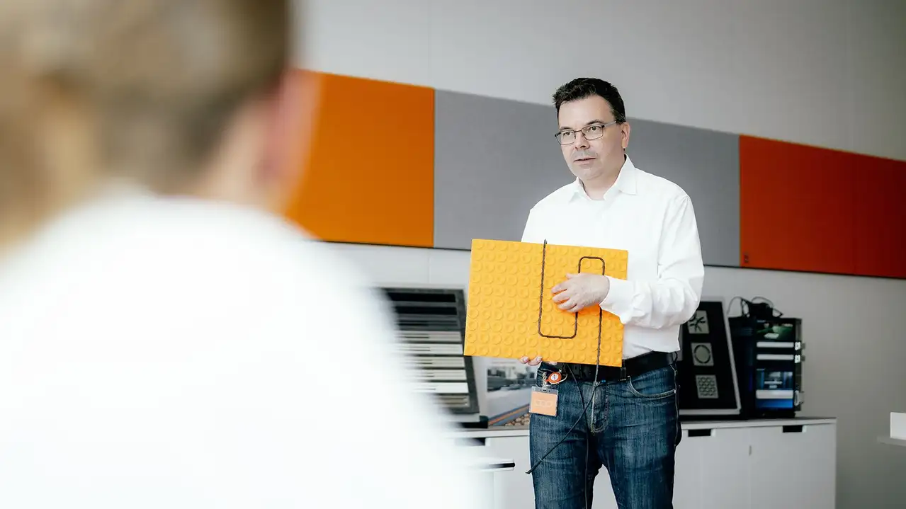 Referent erklärt Schulungsteilnehmern Schlüter-DITRA-HEAT-E.