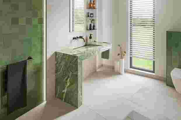 Grünes Badezimmer mit unterfahrbarer Waschtisch und an der dahinter liegenden Wand Schlüter-SHELF.