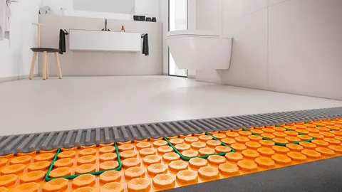 Blick unter die Fliesen eines weißen, großen Badezimmers auf die in der DITRA-HEAT-Matte verlegten Heizkabel 