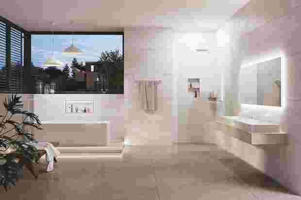 Badezimmer mit freistehender Badewanne, barrierefreier Dusche und zahlreichen Schlüter-Produkten.