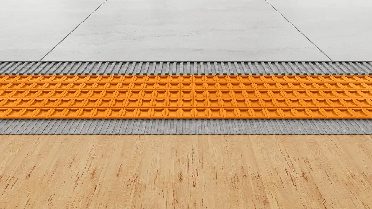 Unterkonstruktion aus Holz mit darauf verklebter orangener Schlüter-DITRA Entkopplungsmatte und hellgrauen Fliesen