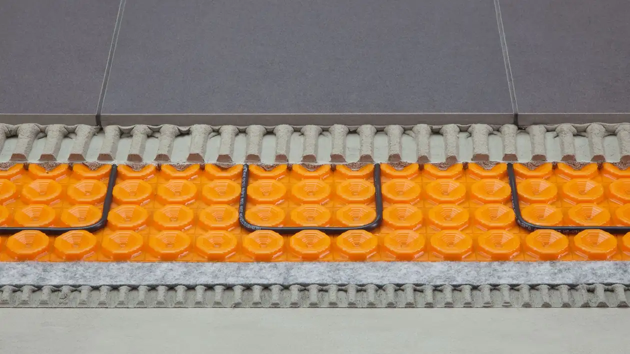 Querschnitt durch einen Fußbodenaufbau mit einer elektrischen Heizung auf Entkopplungsmatte und abschließendem Fliesenbelag