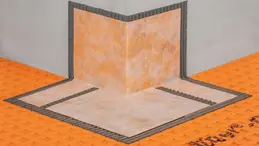 Nahaufnahme einer KERDI-KERECK Au&szlig;enecke, die wandseitig im Fliesenkleber und auf dem Boden auf einer DITRA-Entkopplungsmatte verlegt ist