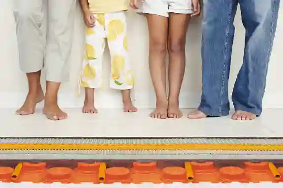 Vier Personen stehen auf Fliesen mit wassergeführter Fußbodenheizung BEKOTEC-THERM.