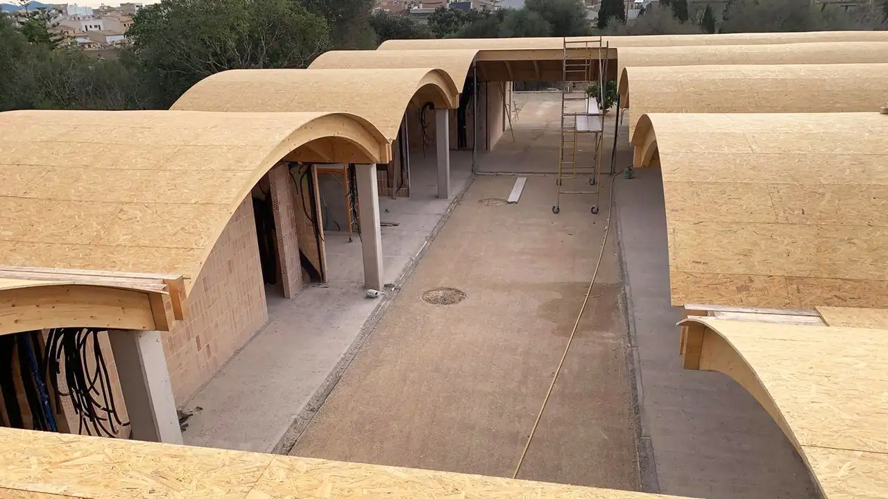 Vista desde arriba de los tejados curvos de la escoleta en fase de construcci&oacute;n con paneles de madera