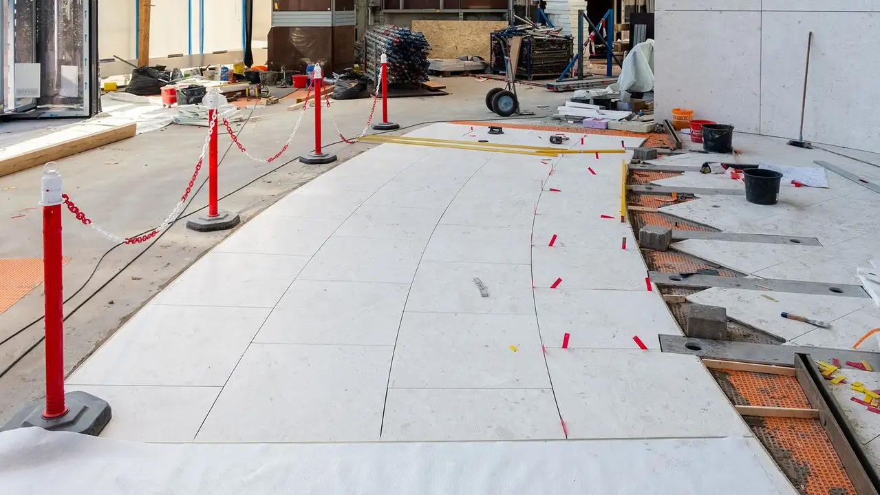 Interior del Messeturm de Frankfurt con losas de piedra natural sobre lámina de desolidarización