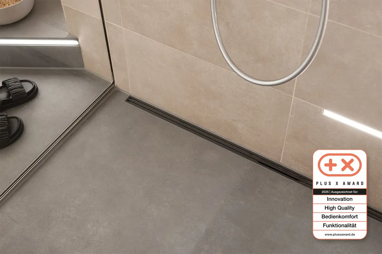 Douche &agrave; l'italienne avec &eacute;vacuation lin&eacute;aire, en bas &agrave; droite : logo du Plus X Award