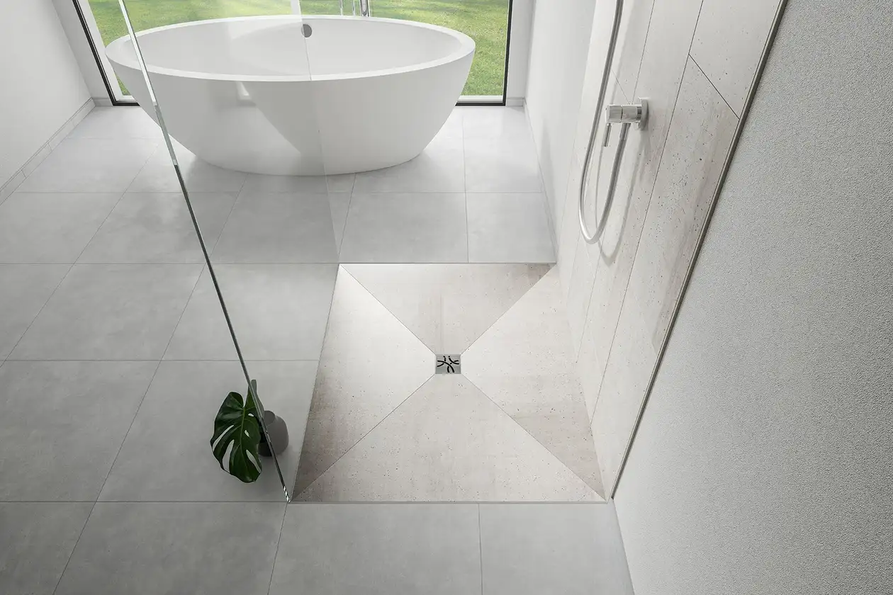 Salle de bains avec baignoire sur pieds et douche accessible avec évacuation KERDI-DRAIN.