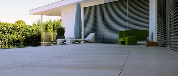 Une maison avec jardin attenant et terrasse où le système Schlüter-TROBA-LEVEL a été mis en œuvre.