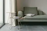 Coin salon avec des carreaux imitation b&eacute;ton et des tables d’appoint en m&eacute;tal