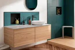 Plan vasque dans une salle de bains avec sol en bois et carrelage couleur p&eacute;trole, dans lequel est int&eacute;gr&eacute;e une Schl&uuml;ter-DESIGN-NICHE noire.