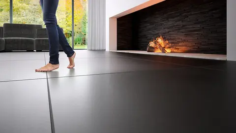 Une femme marche pieds nus sur une surface carrelée à côté d'une cheminée