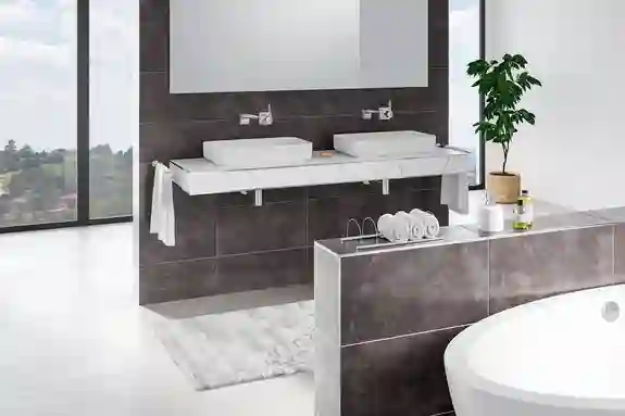 Vue du profilé de finition pour angles sortants de murs Schlüter-JOLLY dans une salle de bains moderne et grise.