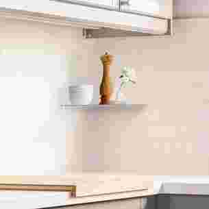 Schlüter-SHELF-E en tant que tablette d'angle pratique et élégante intégrée dans la crédence d'une cuisine