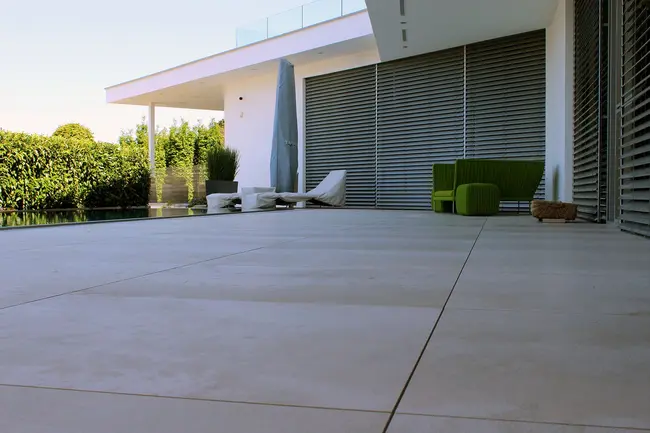 Terrasse partiellement couverte avec dalles de grand format et piscine