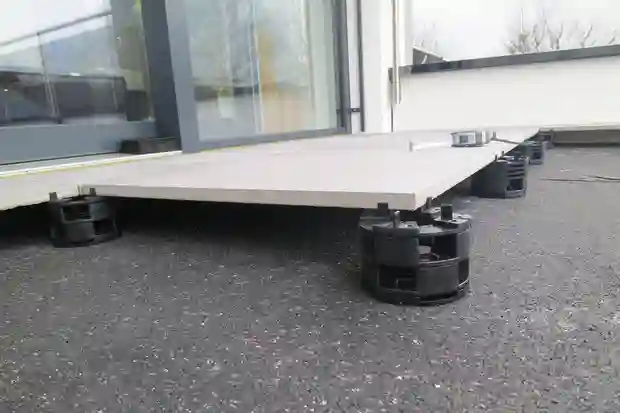 Chantier consacré à la pose d'un nouveau revêtement de sol sur un balcon avec des nattes en polyéthylène, des composants TROBA-LEVEL et des carreaux en céramique