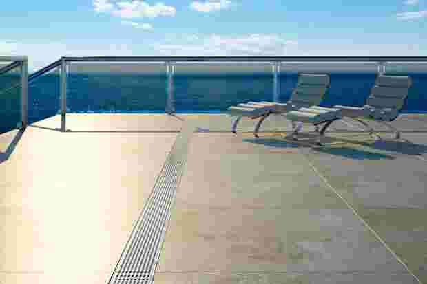 Balcon avec vue sur la mer, chaises longues et caniveau de drainage Schlüter-TROBA-LINE-TL.