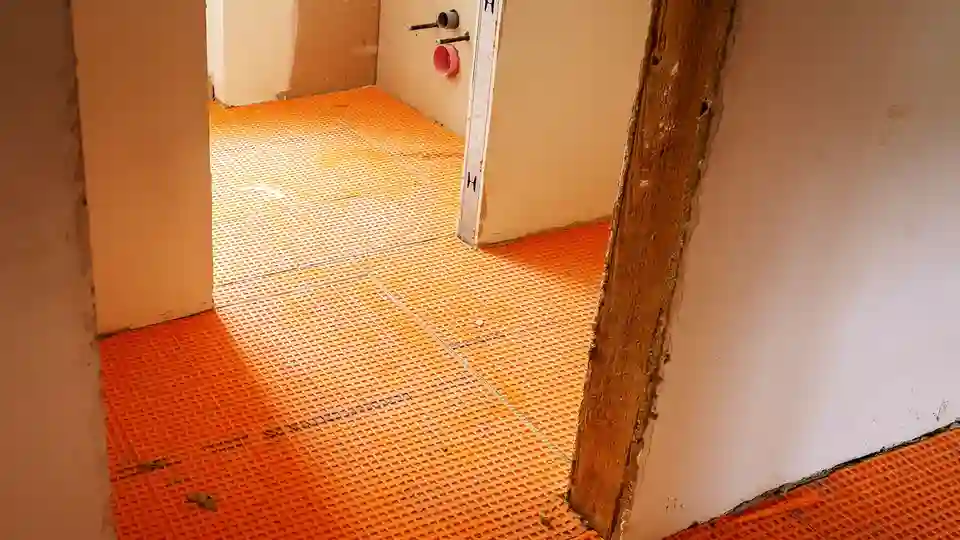 La natte en polyéthylène Schlüter-DITRA 25 est collée au sol dans un appartement